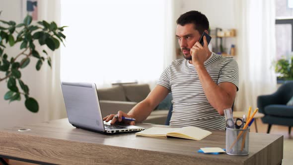 Man with Laptop Calling on Phone at Home Office