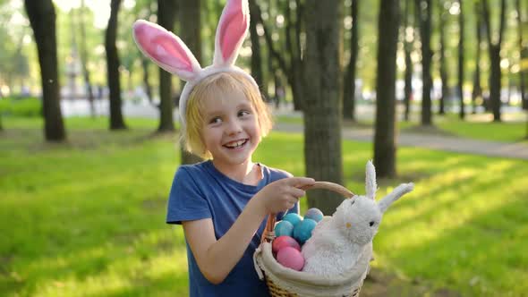 Little boy hunting for egg in spring garden on Easter day