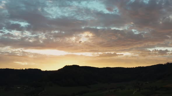 amazing sunset over mountain silhouette aerial view. dramatic clouds with blue and orange color