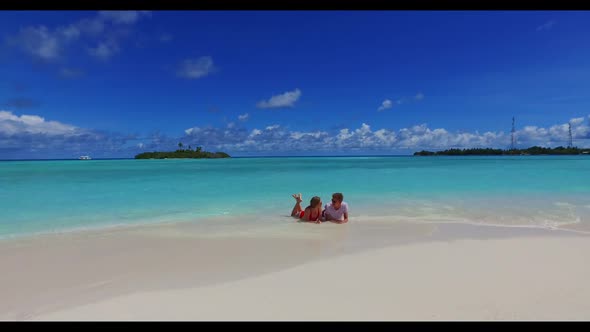 Two people happy together on luxury coastline beach lifestyle by clear ocean and white sandy backgro