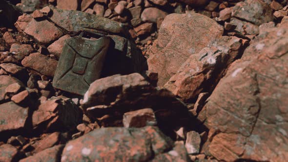 Old Rusty Metal Canister for Gasoline Fuel at Rocks