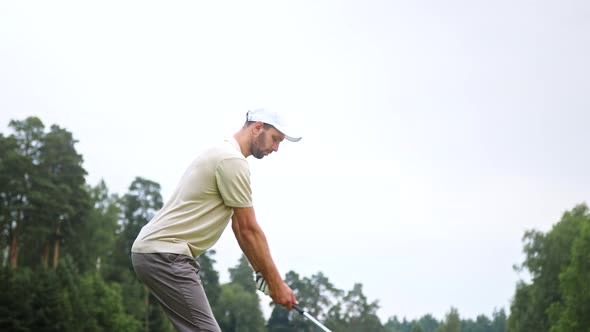 Young sportsman playing golf on the field