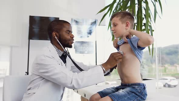 Male Doctor Listening the Heartbeat of Little Boy Using Stethoscope