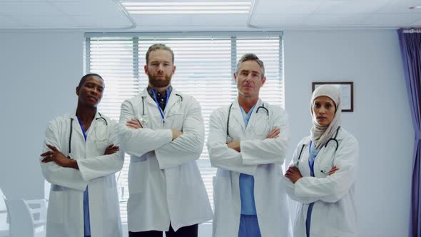 Front view of Multi-ethnic doctors standing together with arms crossed at hospital