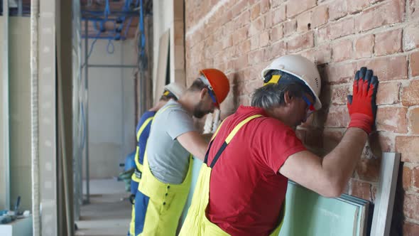 Exhausted Builders Hitting Wall with Heads in Frustration