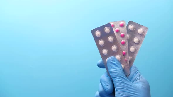 Close Up of Doctor Hand in Protective Gloves Holding Blister Pack