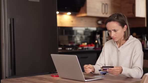 Upset Young Woman Using Online Banking Service Problem with Blocked Credit Card Using Laptop