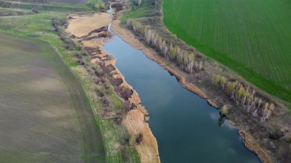 Aerial scenic lake with young green spring fields