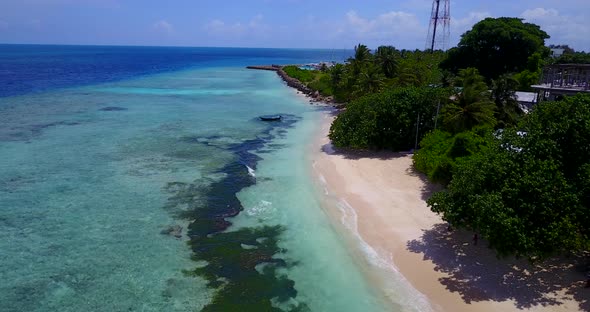 Wide angle overhead tourism shot of a summer white paradise sand beach and blue ocean background in 