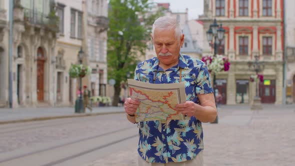 Elderly Stylish Tourist Grandfather Man Walking Along Street Looking for Way Using Paper Map in City