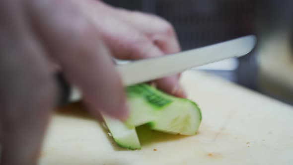 Close Up View of Knife Cutting Cucumber Pieces Into Small Cubes