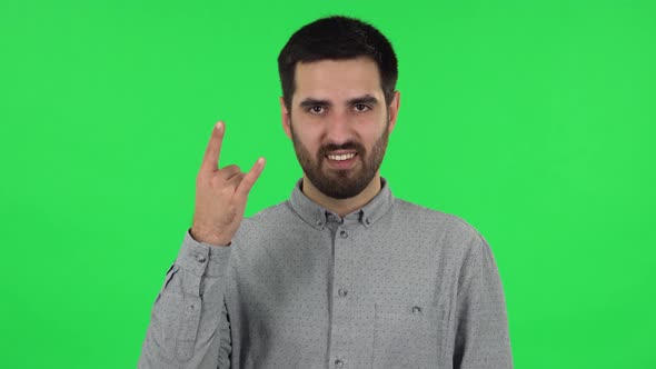 Portrait of Brunette Guy Is Making a Rock Gesture and Enjoying Life. Green Screen