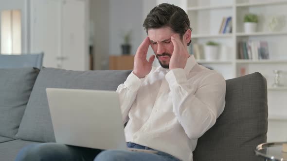 Tired Man with Laptop Having Headache at Home