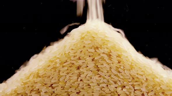 Pouring rice on a black background.