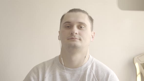 Close-up of Young Brunette Man Saying Goodbye To Colleagues in Video Chat. Portrait of Young