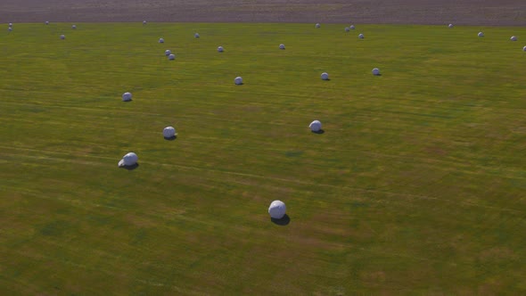 Drone Over Green Field With Covered Hay Bales