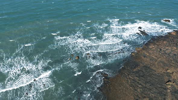 Stone beach and waves aerial shot