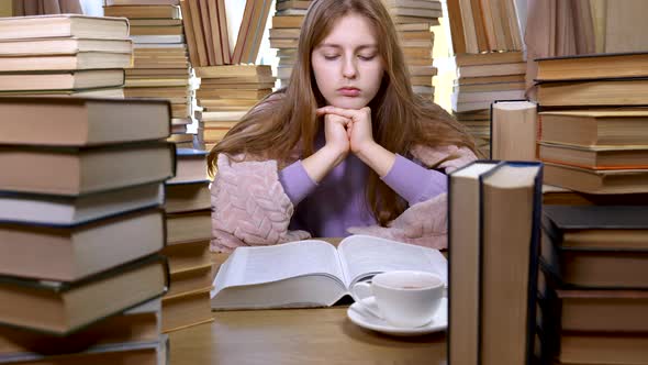 A Girl Reads a Book in the Library