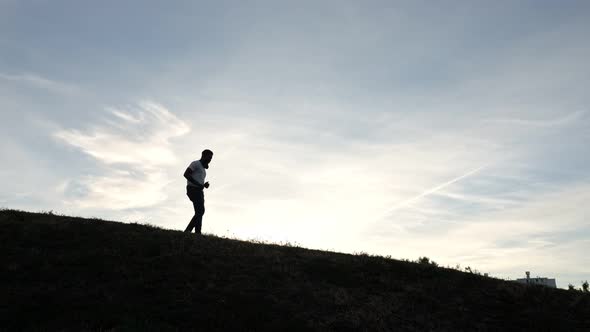 African American Adult Enjoys Sports Running on Hill Top