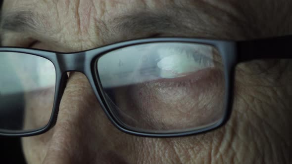 Man with Glasses Looks at the Screen