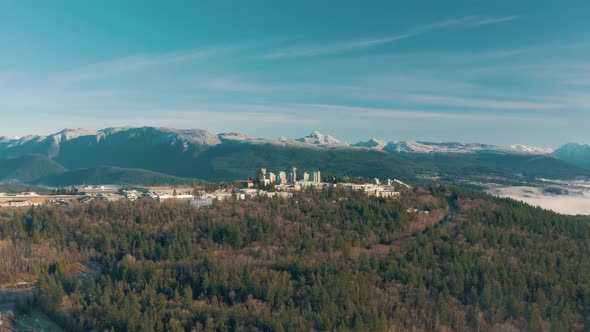 Aerial view of Simon Fraser University on a hill and mountains on background in British Columbia, Ca