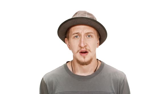 Displeased Young Handsome Man in Hat Over White Background