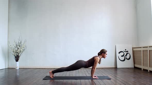 Young and fit woman practicing yoga indoor in the class.