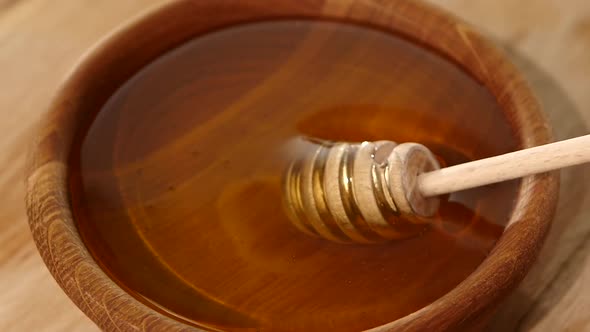 Using Spoon for Honey in Wooden Bowl, Slow Motion