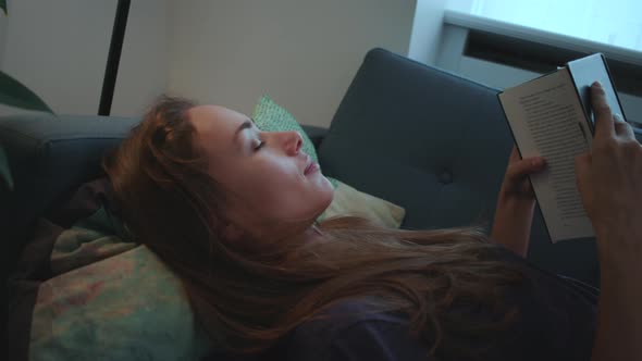 Woman Reading And Relaxing On Sofa