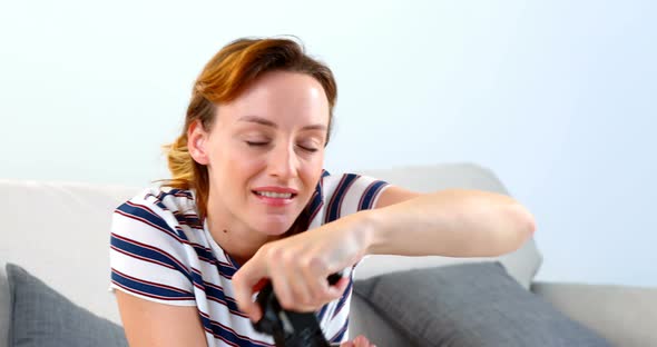 Woman playing joystick game on sofa 