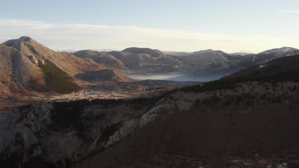 Aerial drone view above mountainous Kotor Bay at sunrise in bright morning