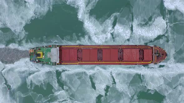Aerial Epic Red Ship in Winter Sails Through Frozen Sea Makes Its Way. Ice Floe Graphic Pattern
