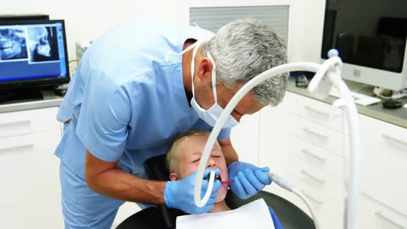 Dentist examining a young patient with tools