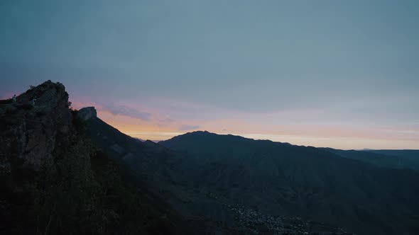 Sunset over dark mountain valley