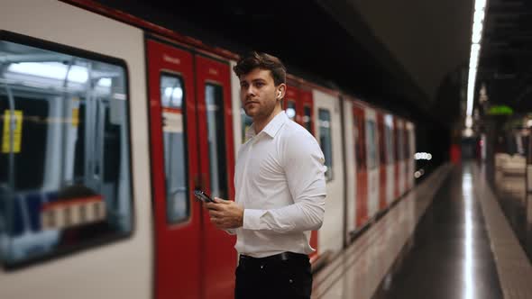 Businessman with Smartphone Waiting for Train