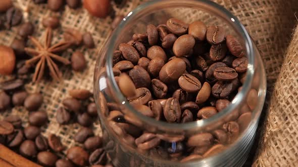 Top of Pouring Coffee Beans Into a Bottle on Background with Hazelnut, Anise, Slow Motion