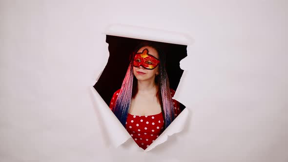 Young Woman in Red Dress and Masquerade Mask Posing in Studio