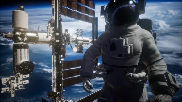 International Space Station and Astronaut in Outer Space Over the Planet Earth alt