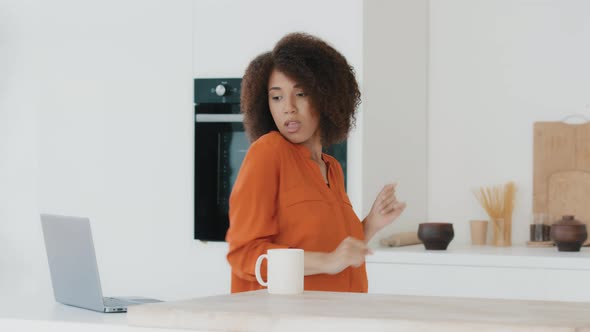 African American Girl with Curly Hair Woman Dancing in Kitchen at Home Having Fun Listening to Music
