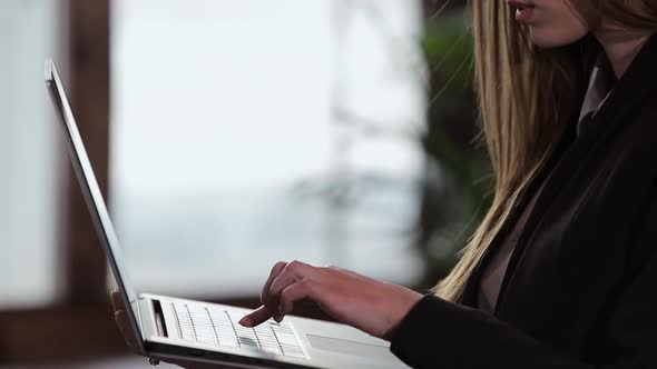 Confident Businesswoman Working on a Laptop in Her Modern Blue Modern Office Interior. Stylish