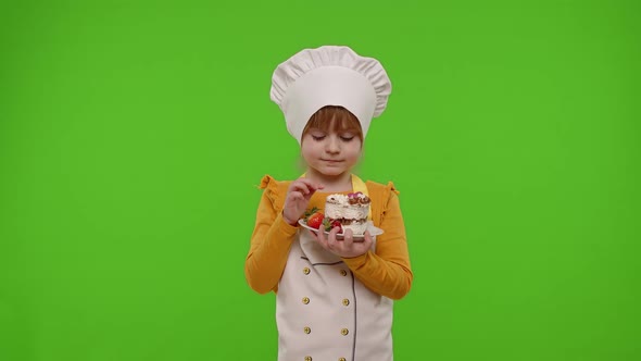 Child Girl Kid Dressed As Professional Cook Chef Baker Eating Tasty Strawberry Cake on Chroma Key