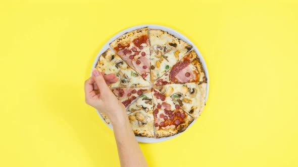 Woman's hand snaps her fingers and pizza appears on an white plate.
