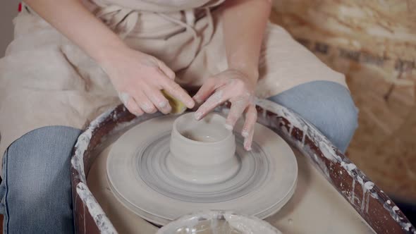 Woman Shaping Vase on a Potter's Wheel.