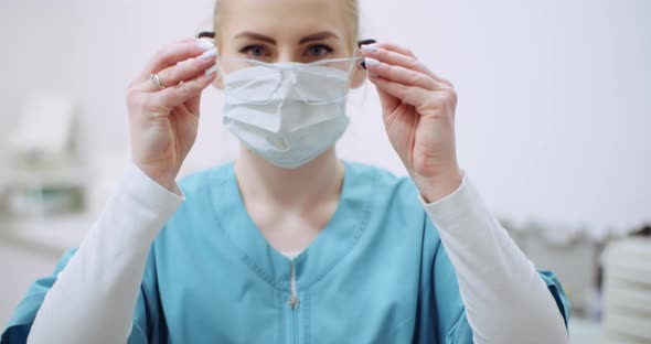 Female Doctor Wearing Protective Mask on Face and Put Glasses. Doctor at Healtcare Clinic