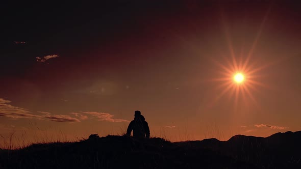 A Man Runs With His Dog At Sunset In The Mountains