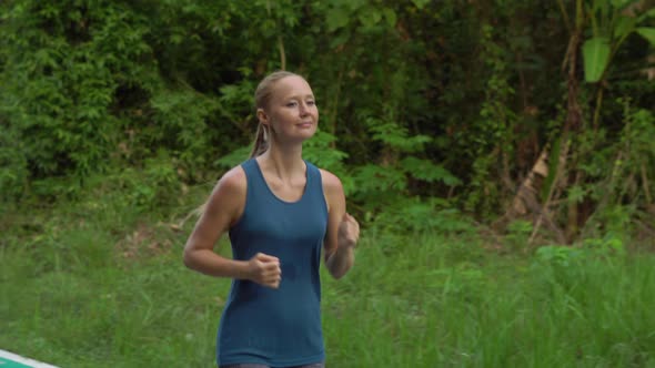 Steadicam Shot of a Young Woman Running in a Tropical Park