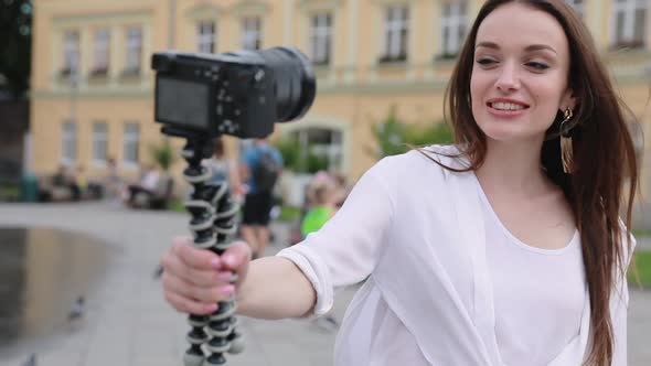 Woman Recording Video For Vlog On Camera Outdoors