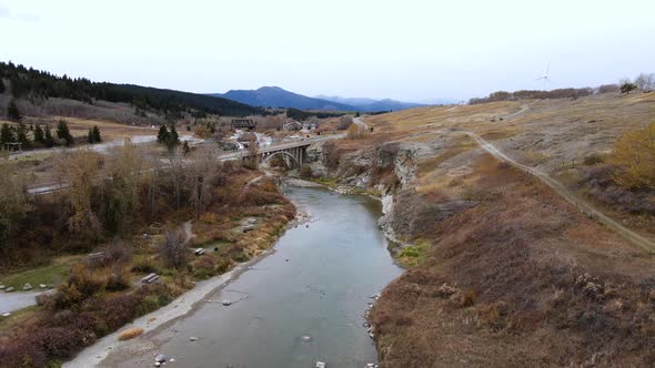 Aerial slow motion footage of an open spandrel deck arch bridge near lundbreck falls in Canadian pra