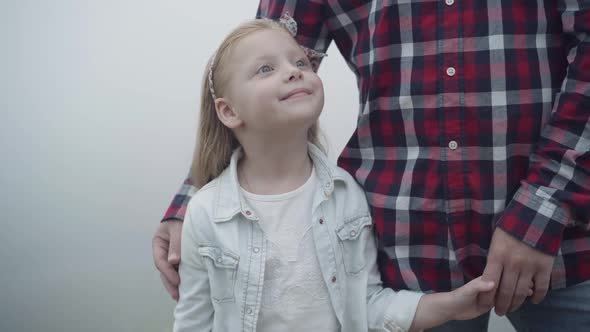 Portrait of Happy Charming Beautiful Girl Standing with Unrecognizable Man Outdoors Smiling Looking