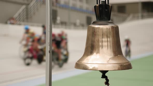 Hand rings bell on cycling track velodrome